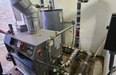 Commercial boiler and water heater system with insulated piping installed in a mechanical room.